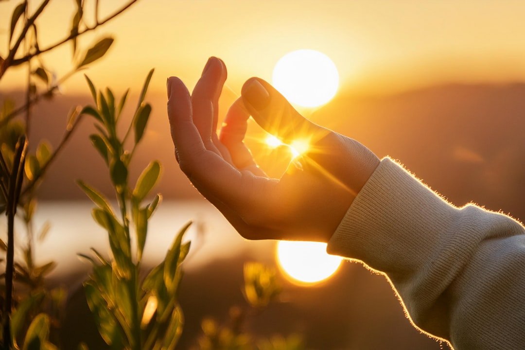 A hand raised against golden sunset light